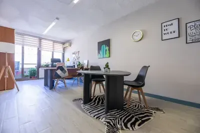 Una habitación con una mesa y sillas y una alfombra de cebra en el suelo.