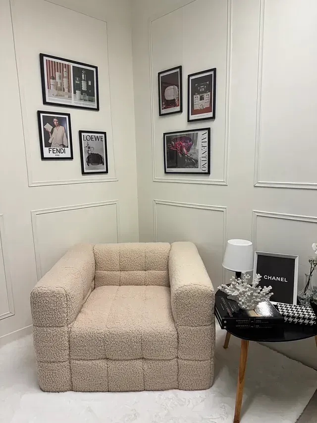 Una silla está colocada en un rincón de una habitación con cuadros en la pared.