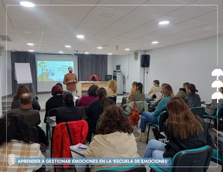 Un grupo de personas está sentada en un aula viendo una presentación.