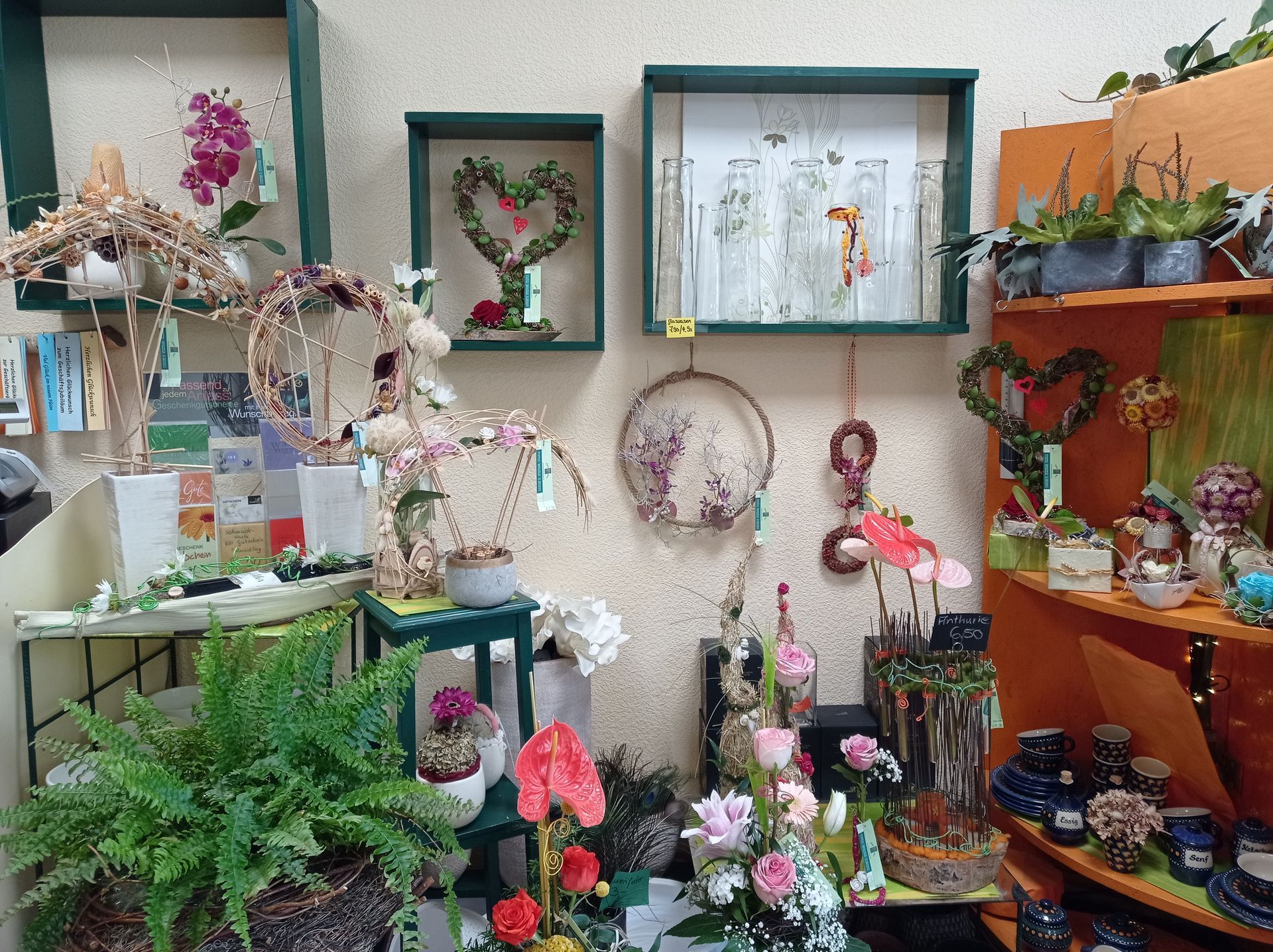 Die Inneneinrichtung eines Blumenladens mit bunten Blumen und dekorativen Arrangements auf Regalen und Tischen.