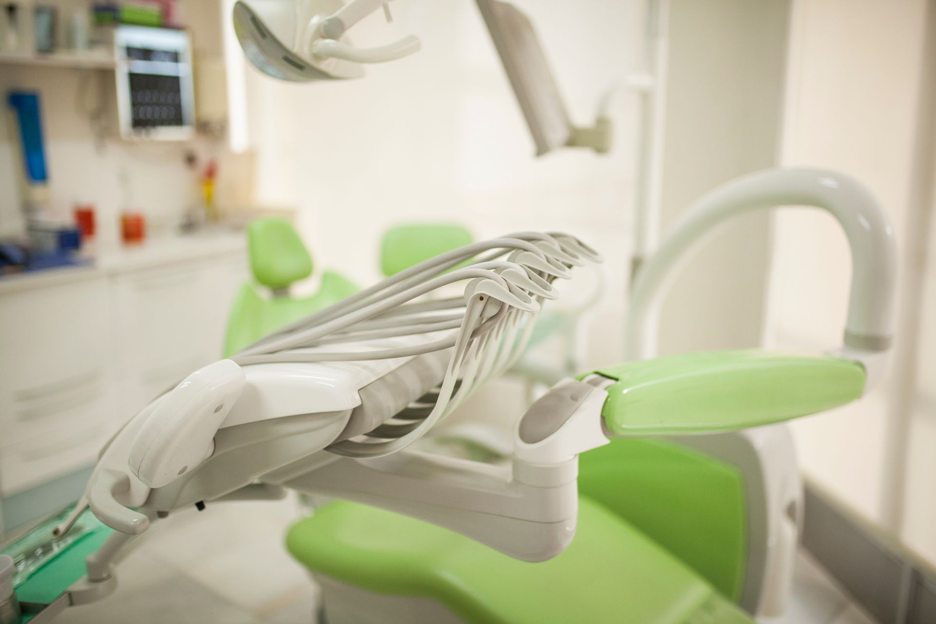 Un dentista in camice blu esamina i denti di un paziente in uno studio dentistico.