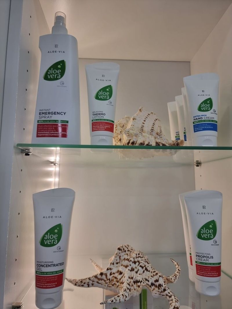 Mehrere Flaschen Aloe Vera Lotion stehen auf einem Glasregal