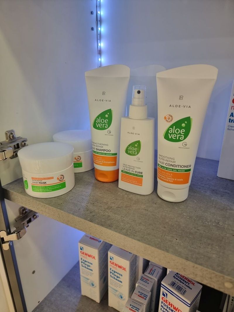 Ein Regal voller Flaschen mit Aloe-Vera-Produkten.