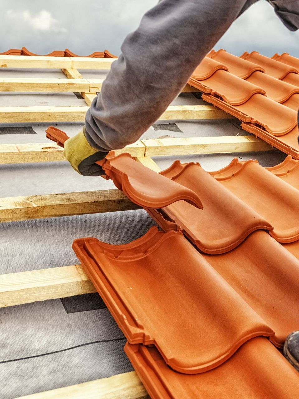Pose d'une tuile sur un toit