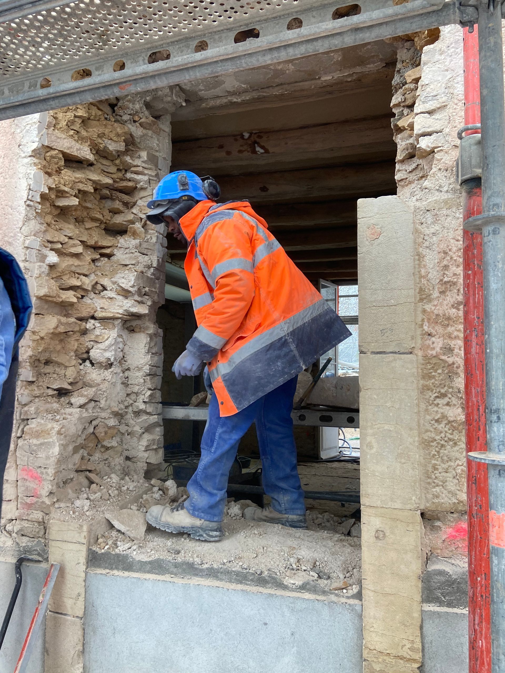 Travailleur en vêtement de sécurité sur un chantier de rénovation.