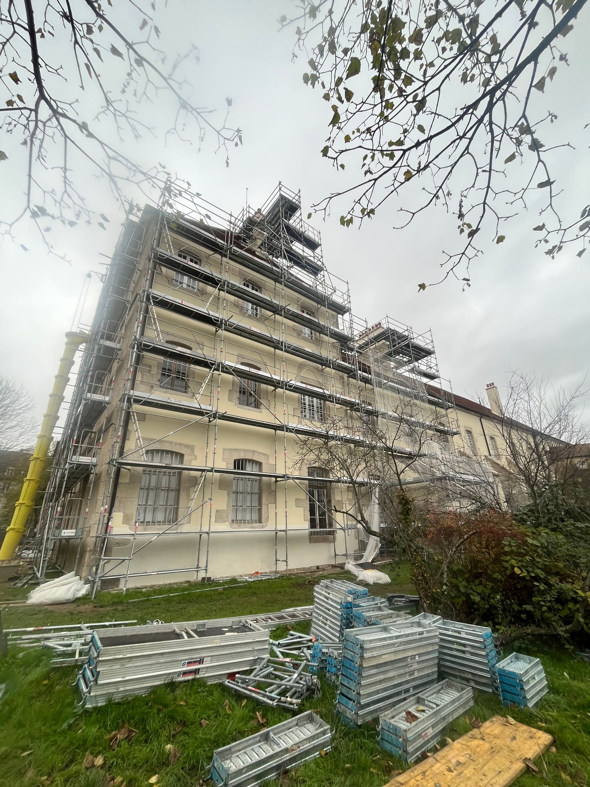 Bâtiment ancien en cours de rénovation avec échafaudages.