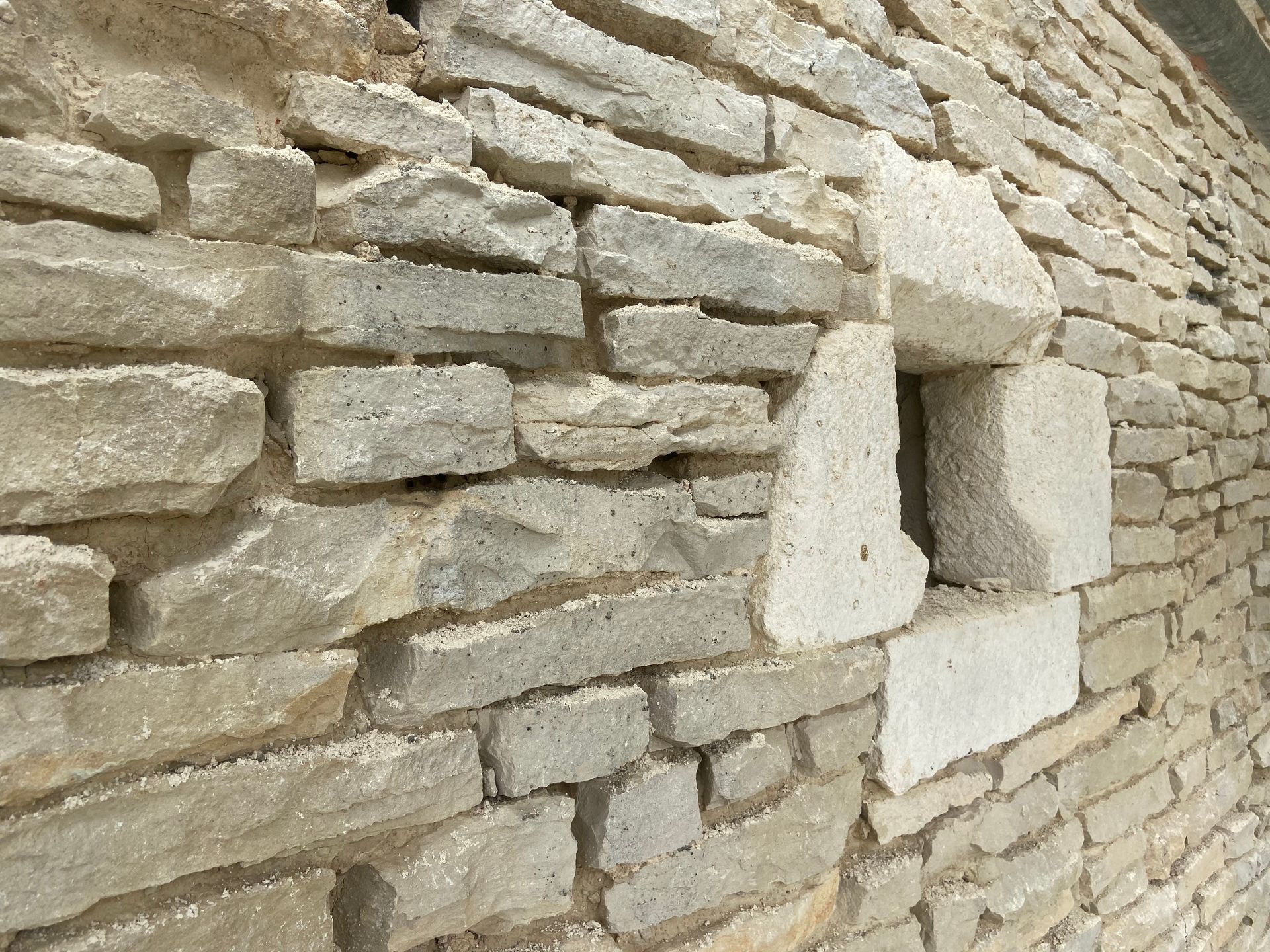 Gros plan sur un mur en pierre avec des détails de maçonnerie.