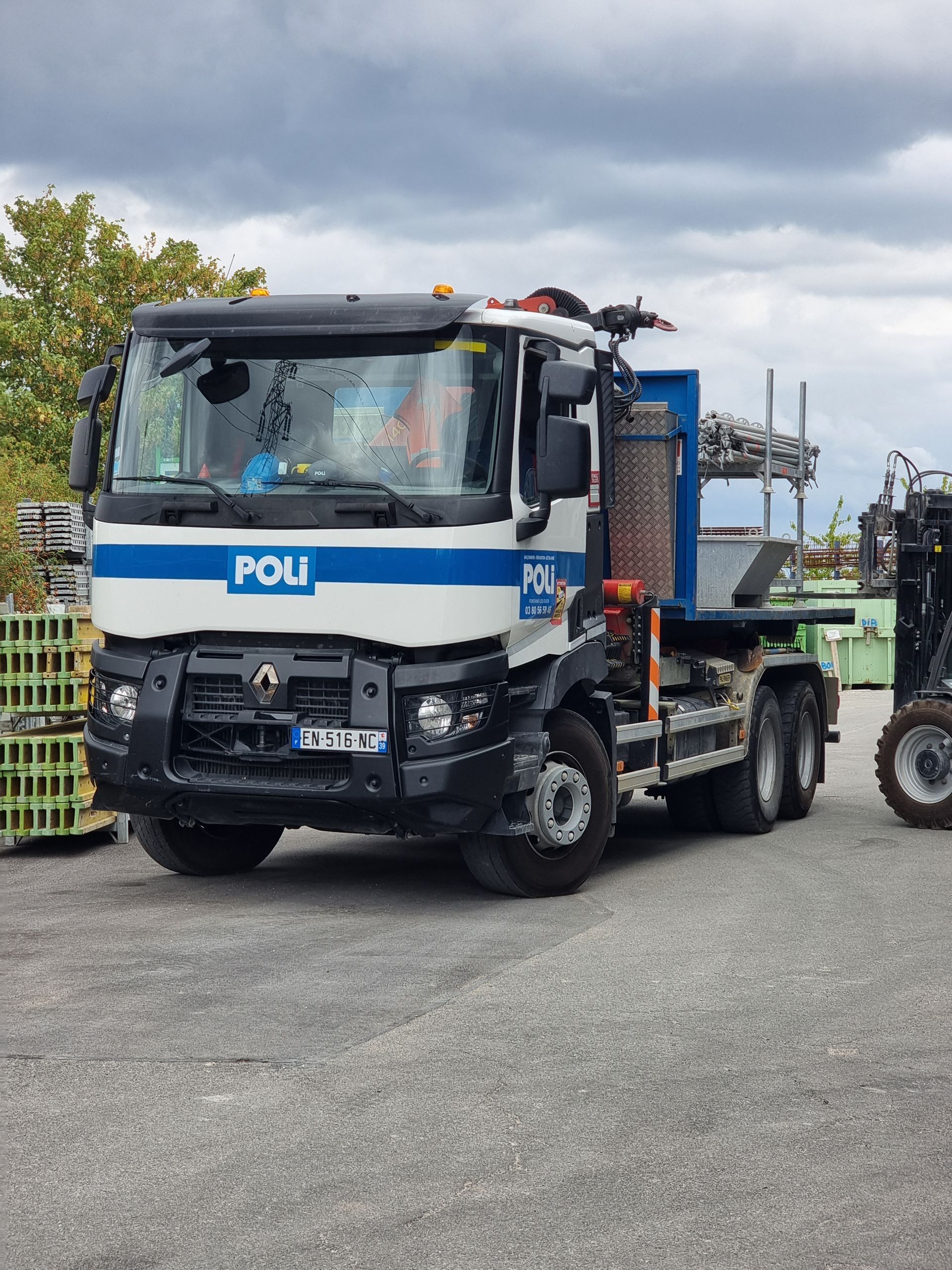 Camion de l'entreprise POLI avec grue de manutention.
