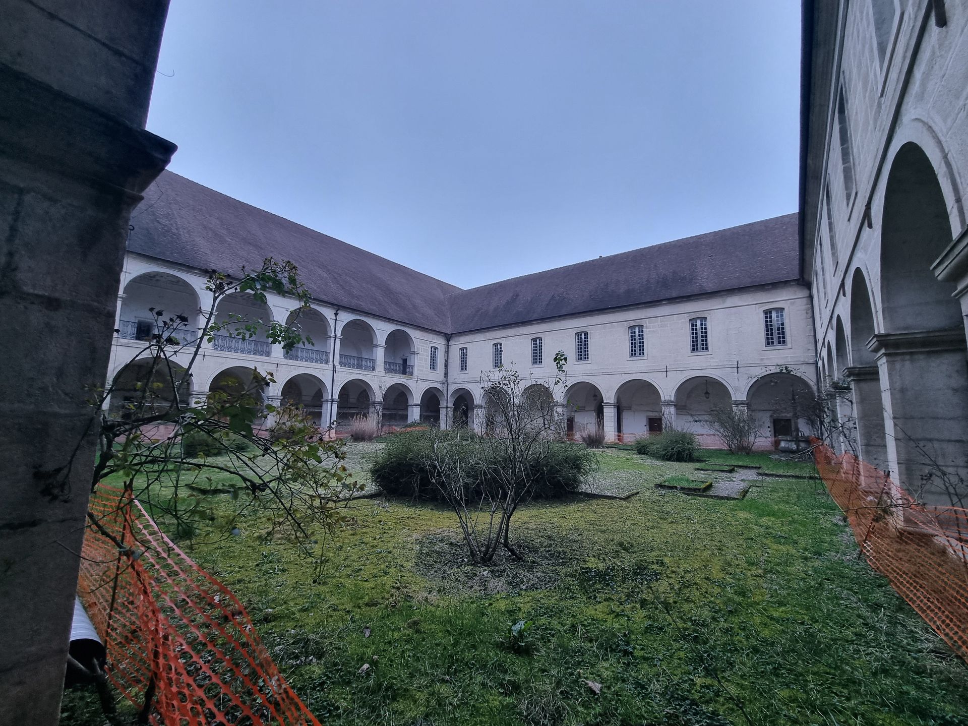 Bâtiment historique avec une cour intérieure et des arches.