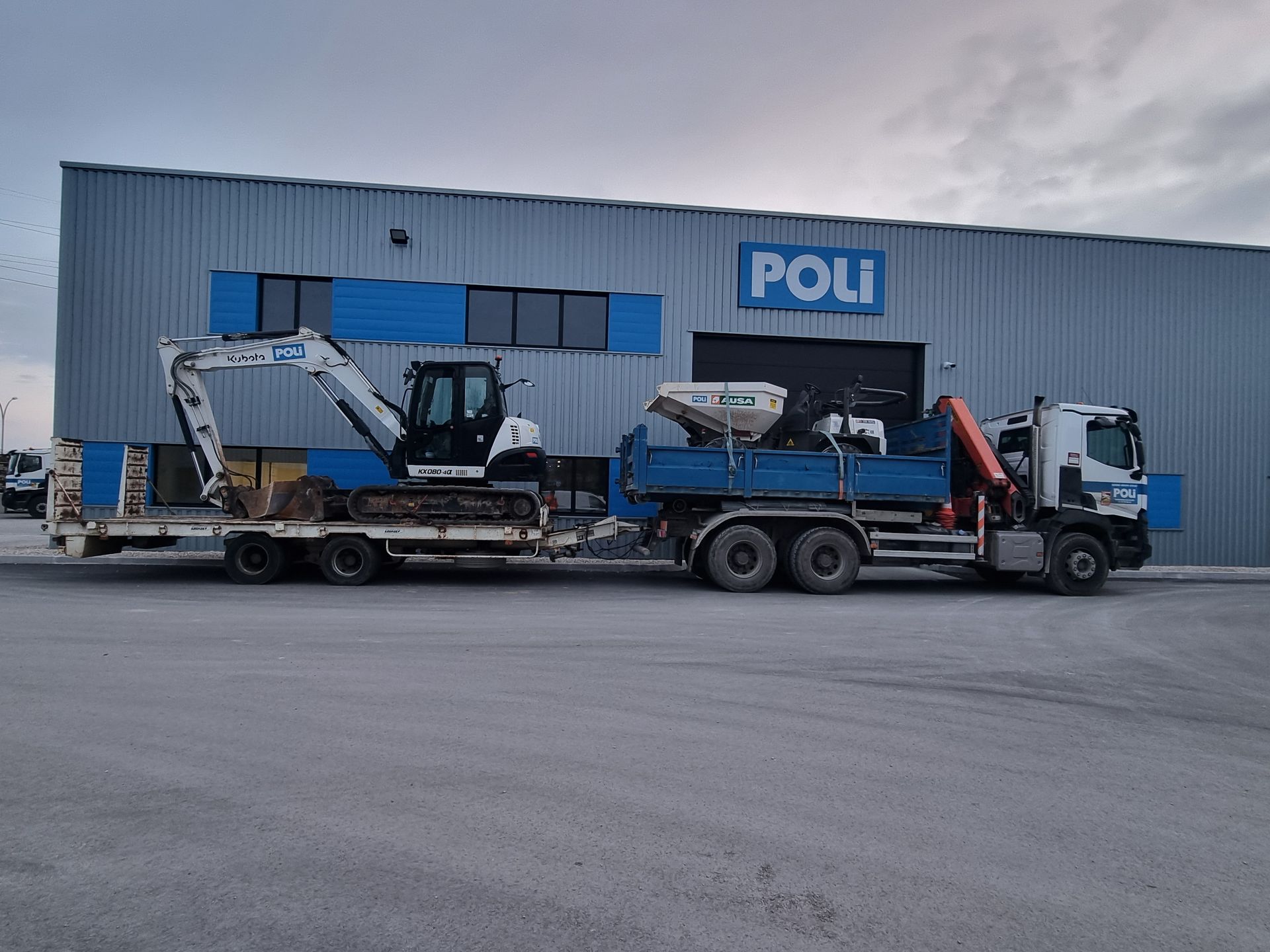 Camion-grue avec un engin dans la remorque tirant une autre remorque contenant une mini pelle blanche.