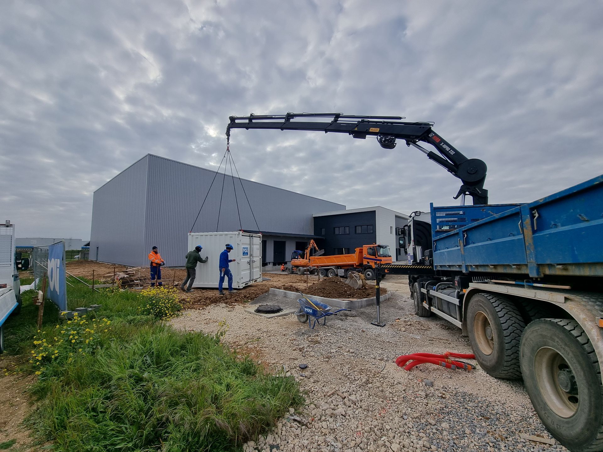 Camion Grue en train d'être utilisé pour soulever un conteneur.