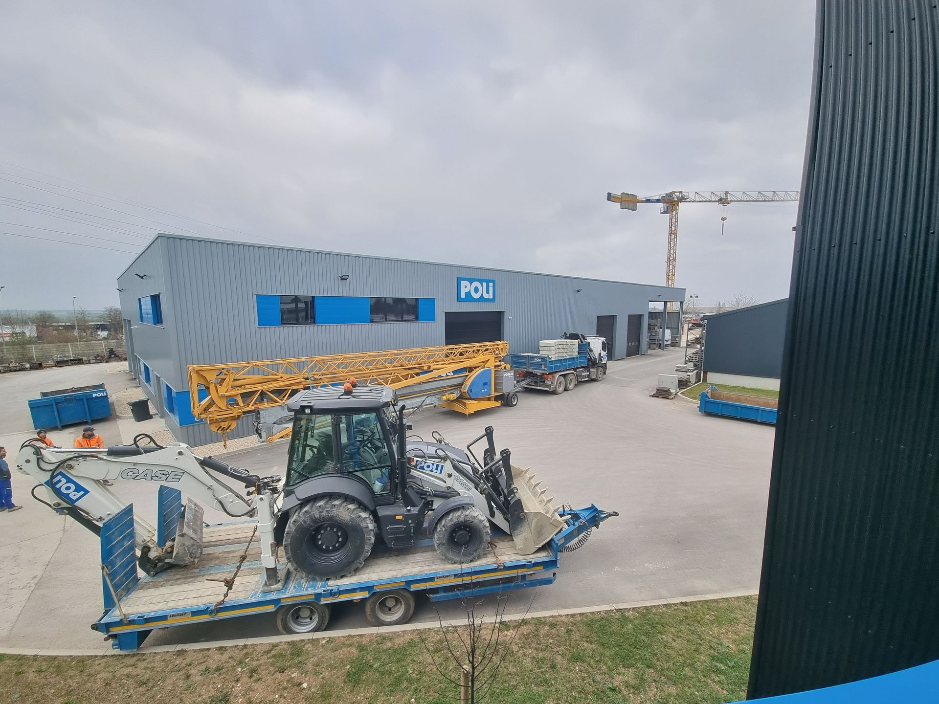 Tracteur sur une remorque dans la cour de l'entreprise POLI.