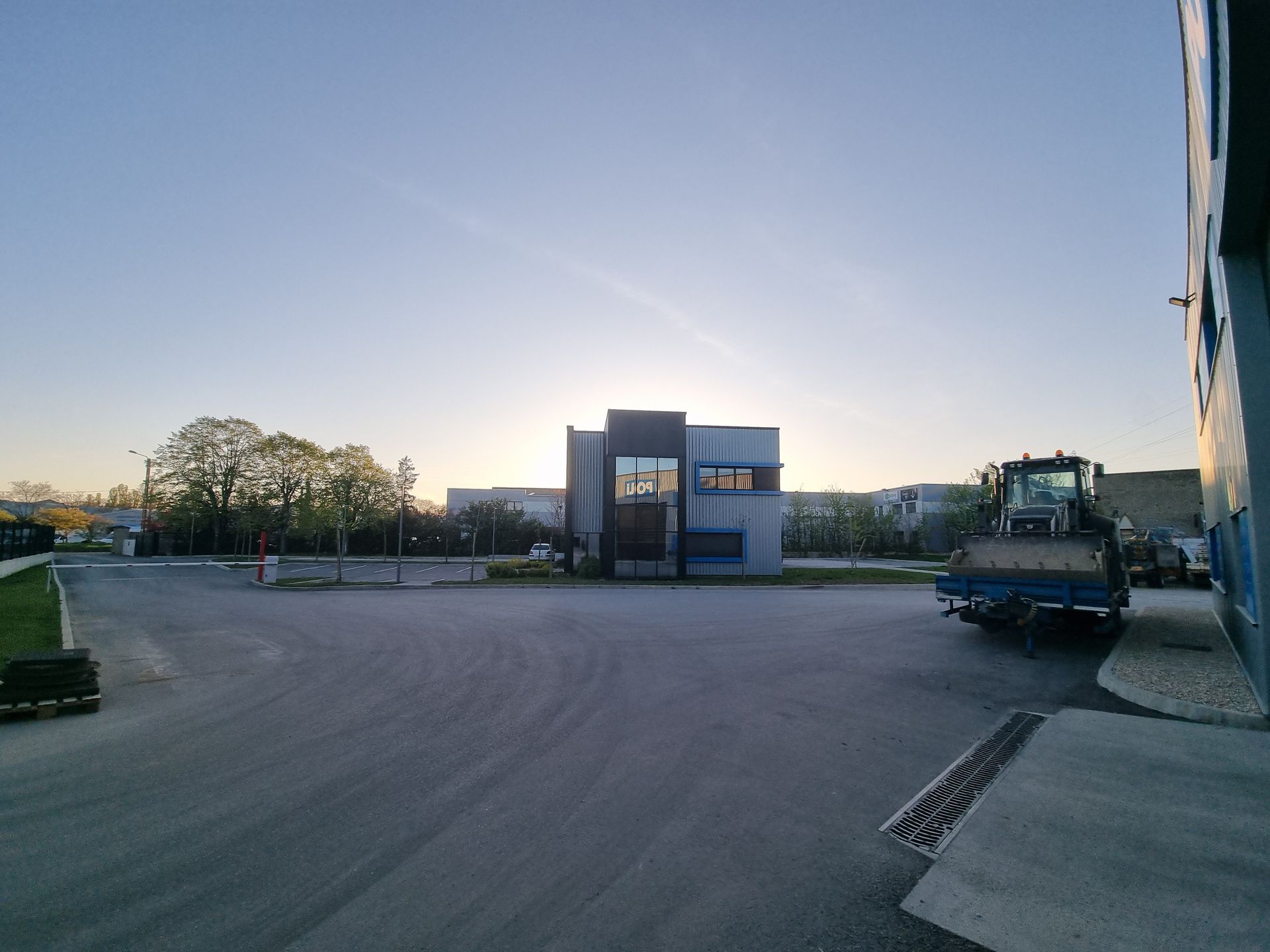 Bâtiment industriel moderne sous un ciel crépusculaire.