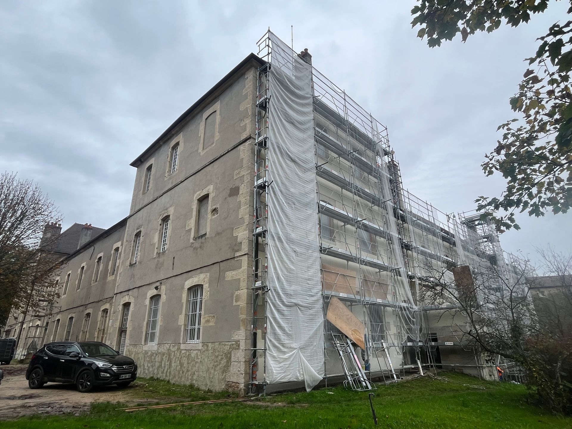 Bâtiment ancien sur deux étages en cours de rénovation avec échafaudages.