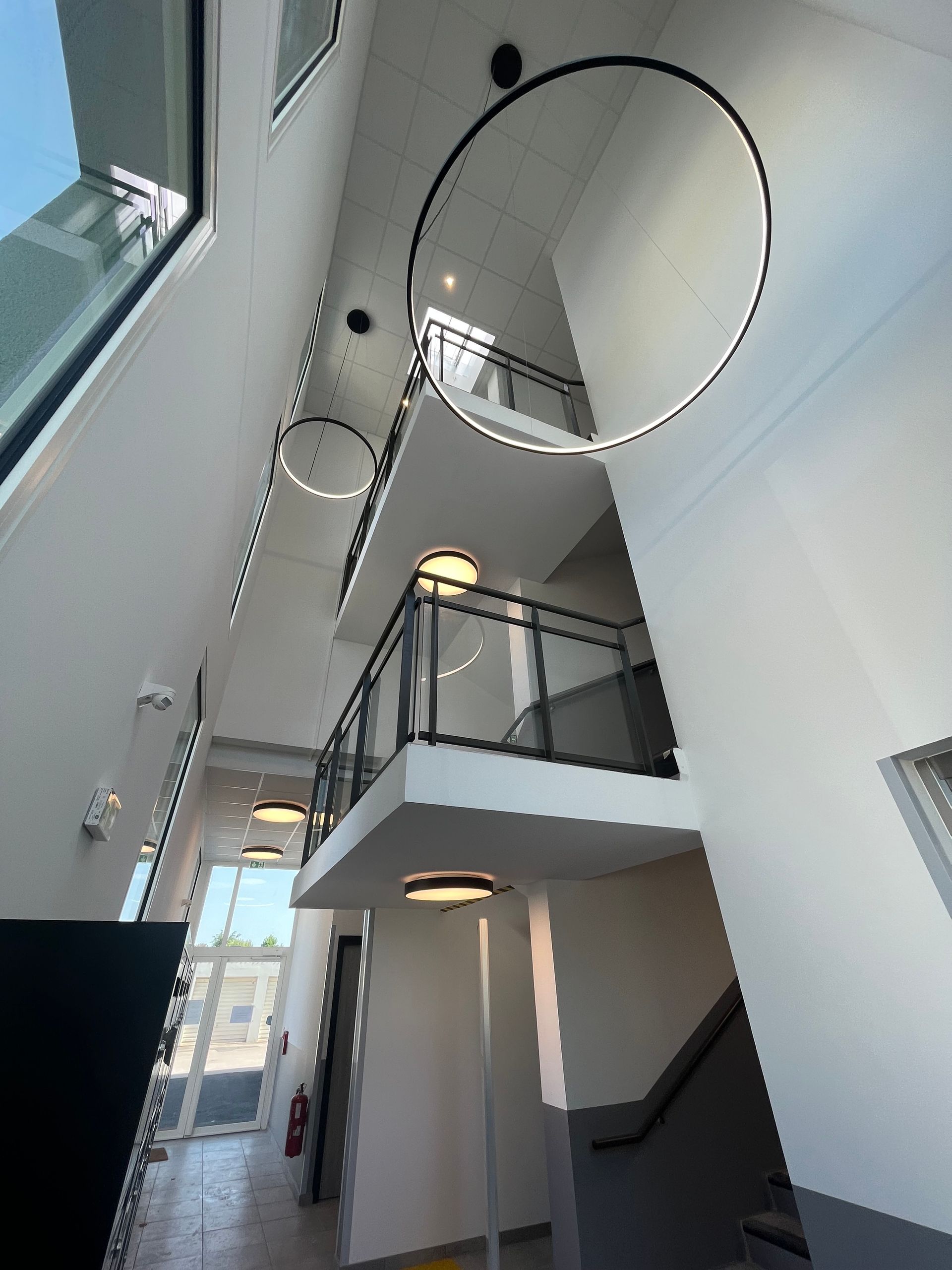  Intérieur d'un bâtiment moderne avec un escalier en colimaçon et des structures en métal. La pièce est bien éclairée et semble être un espace de vie ou de travail contemporain.
