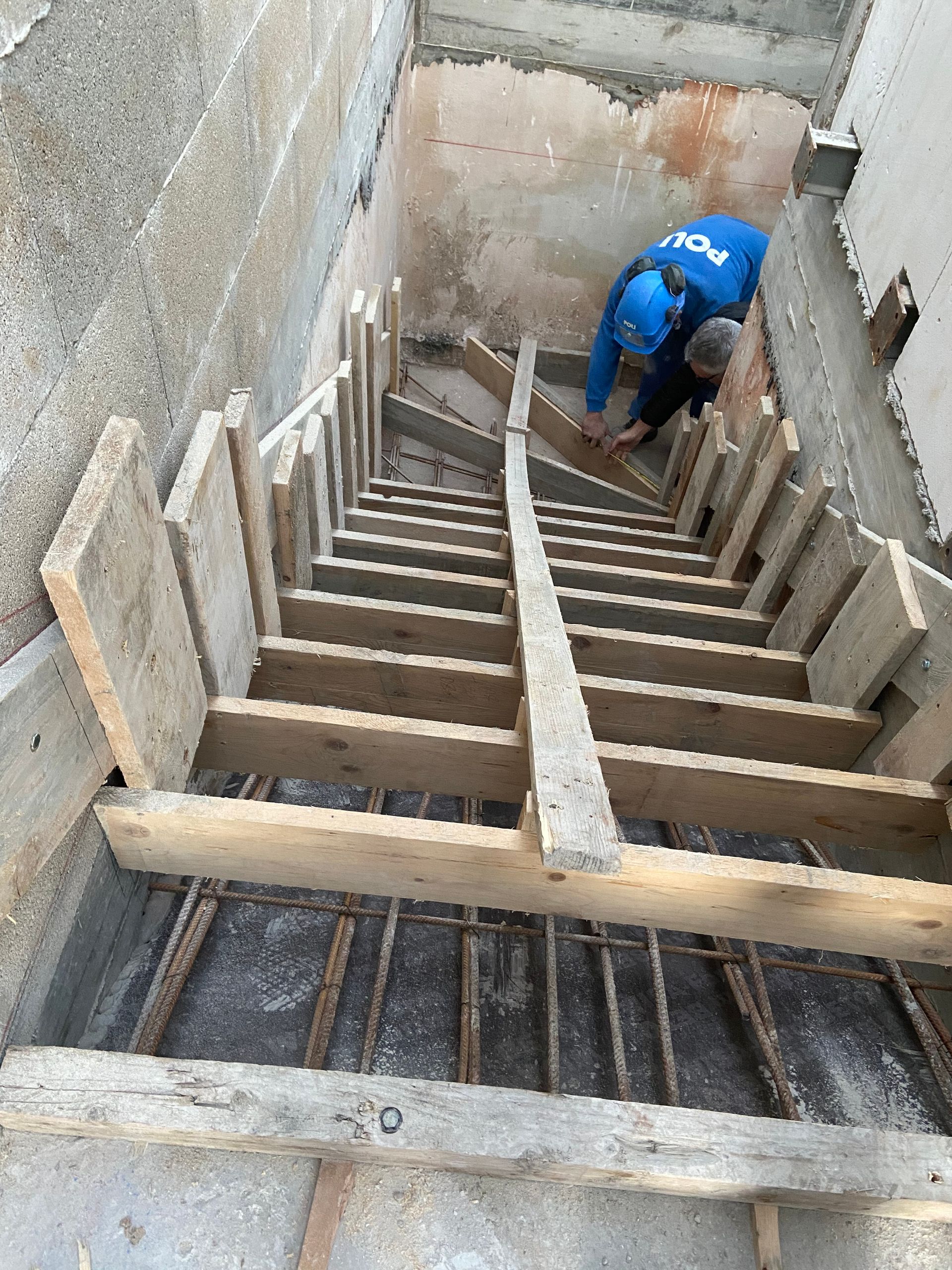 Escalier en construction avec un coffrage de structures en bois et métal.