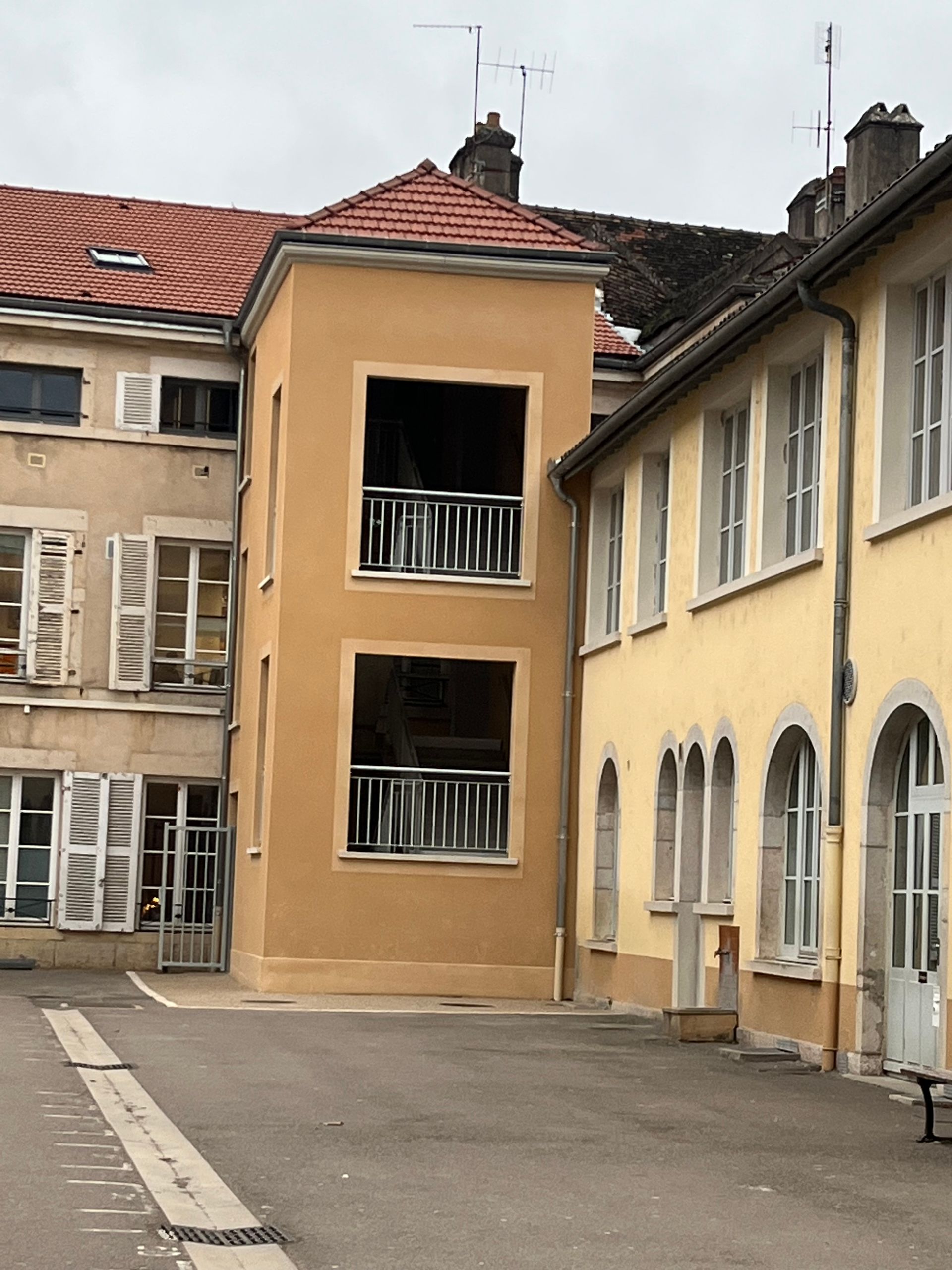 Façade de plusieurs batiment avec au milieu une façade orange refaite.