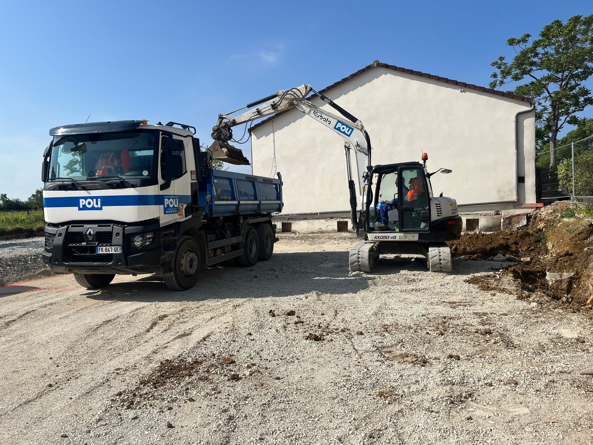 Pelle mécanique en train de charger de la terre dans un camion benne.