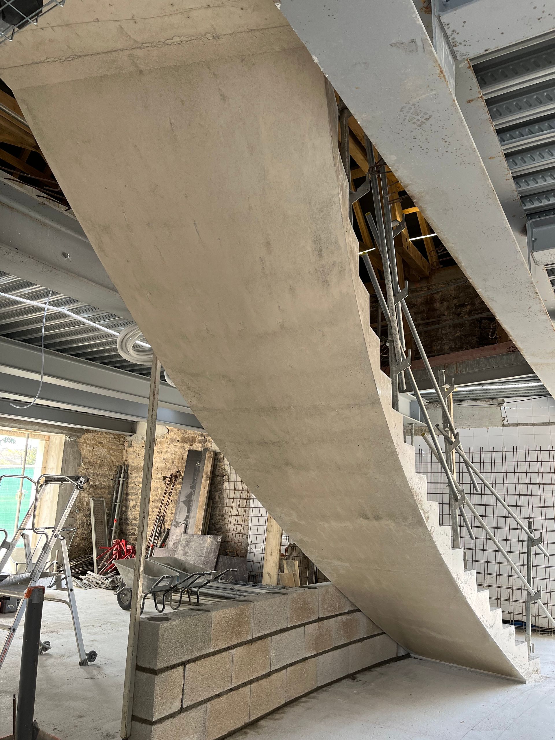 Vue de dessous d'un escalier en cours de construction en béton.