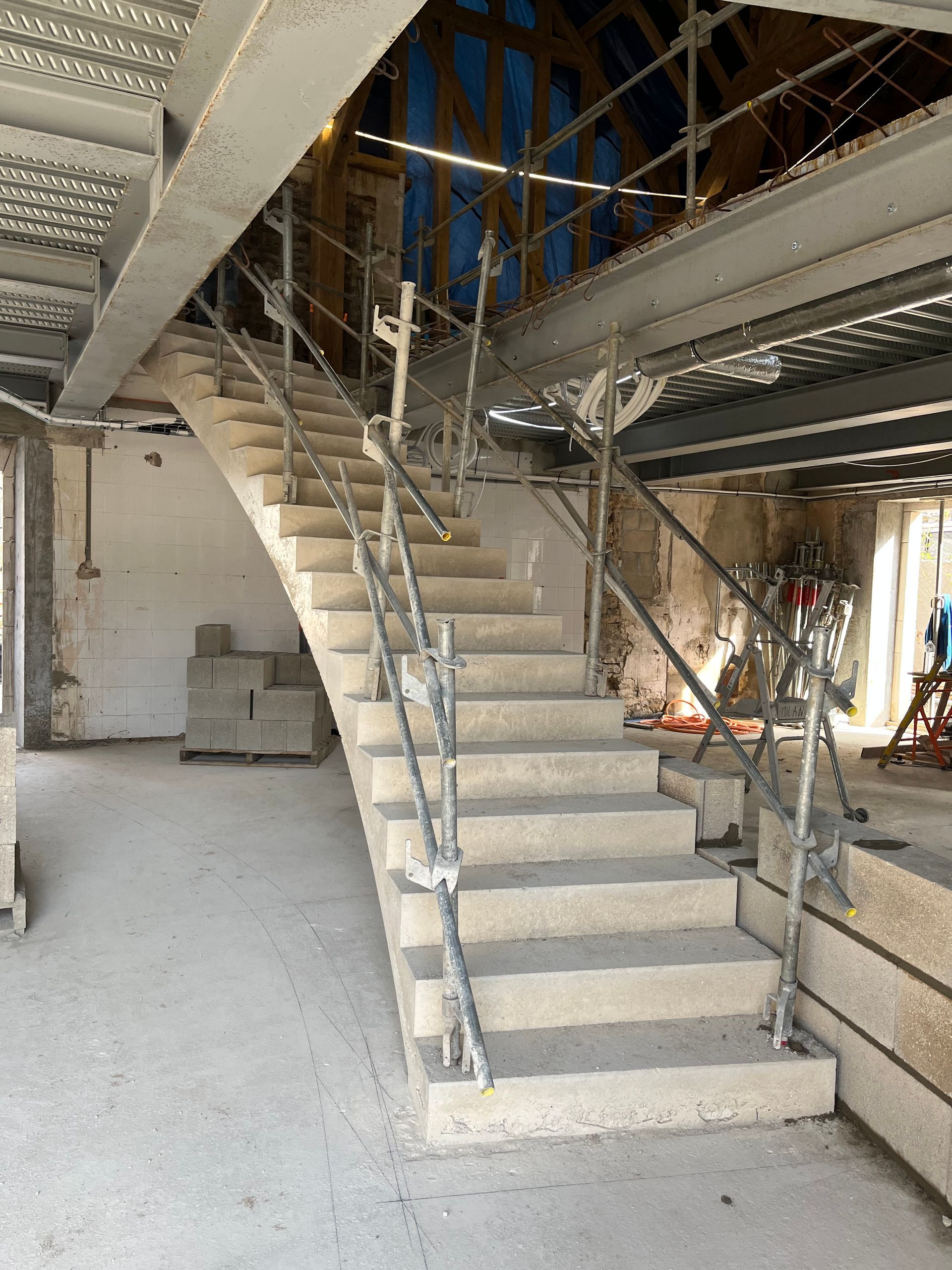 Escalier en construction avec des structures en bois et métal.