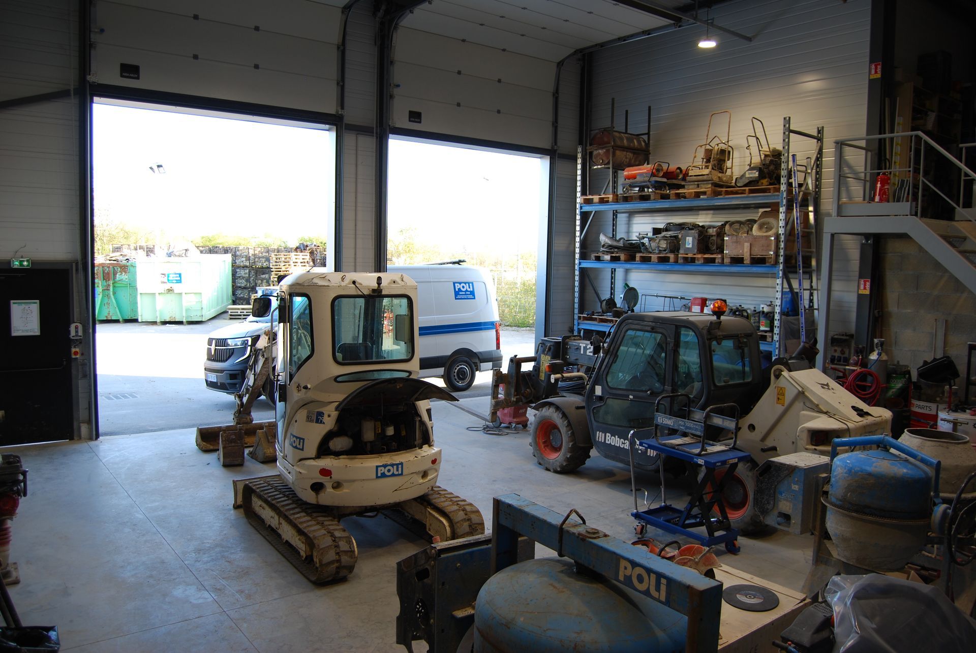  Intérieur d'un bâtiment industriel avec des équipements et des véhicules.