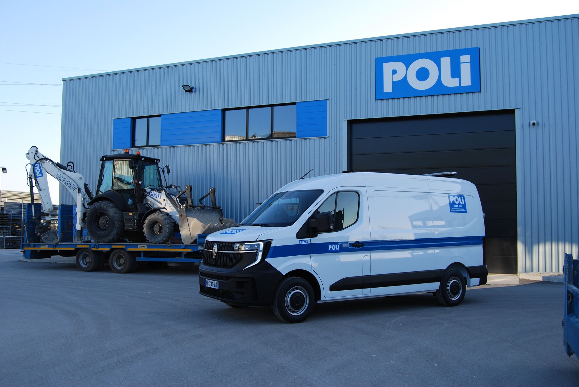 Photo d'un utilitaire de l'entreprise POLI devant cette même entreprise et un tracteur sur une remorque.