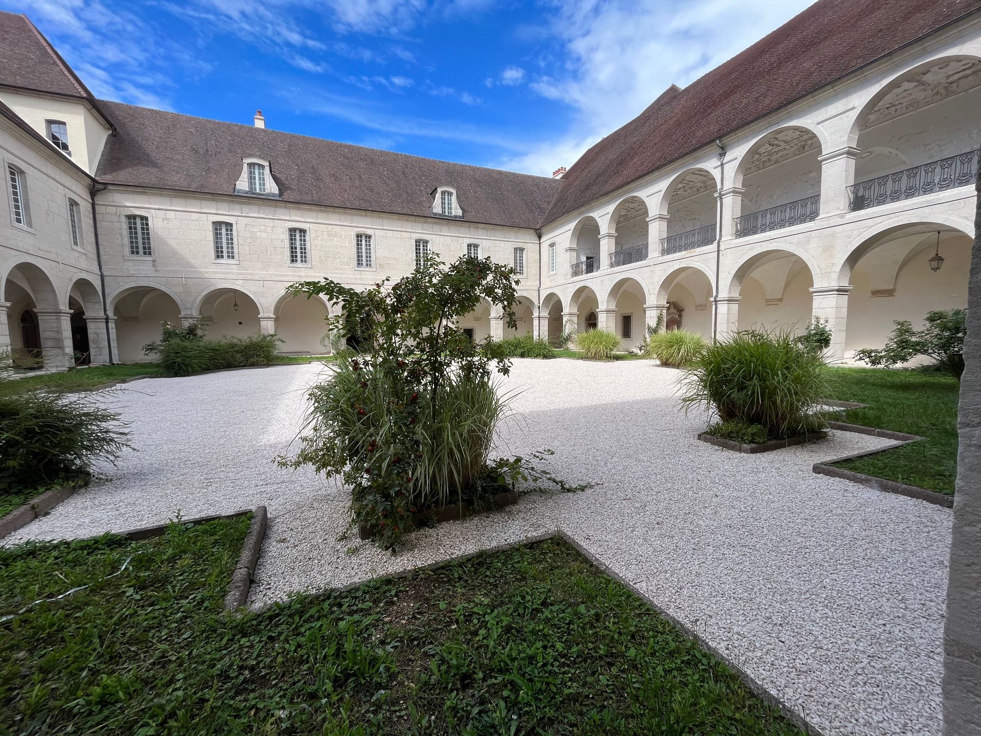 Bâtiment historique avec une cour intérieure et des arches. La structure a été rénovée.