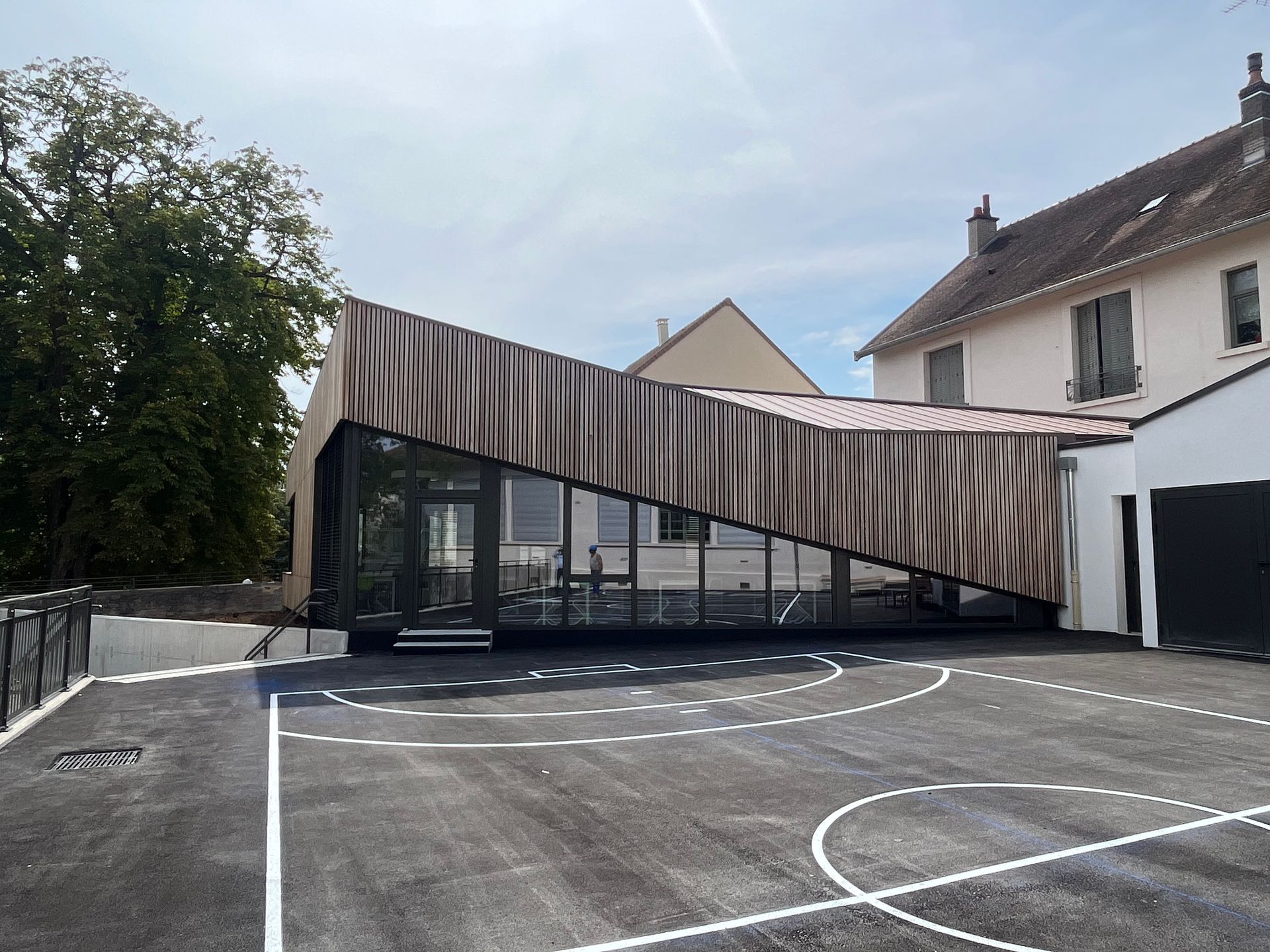 Bâtiment moderne avec une façade en bois et des structures en métal.