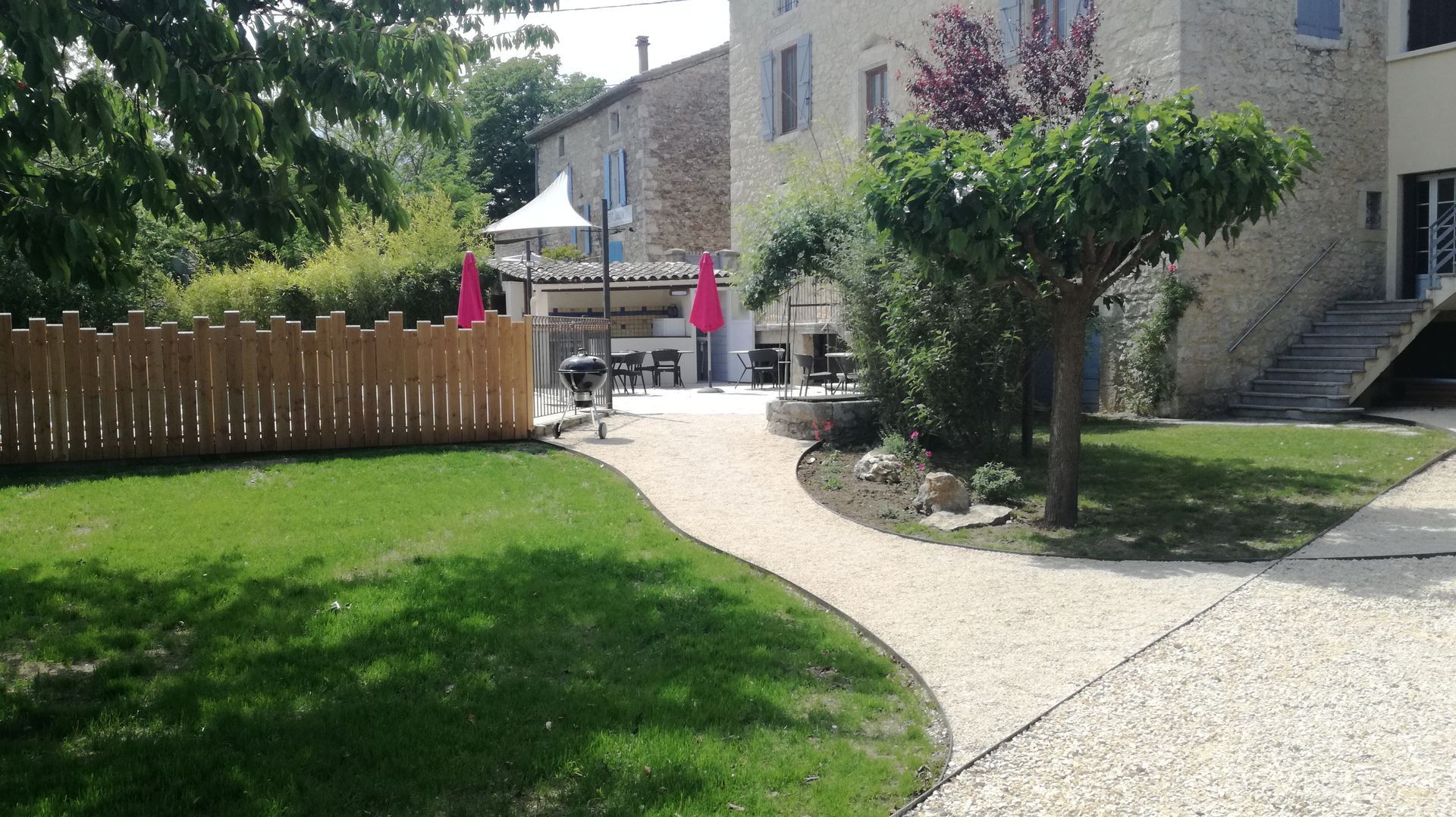 Aperçu d'un édifice avec une voie de gravier et un jardin verdoyant.