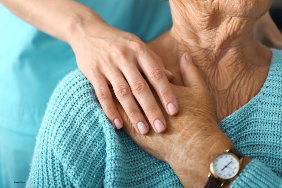 Person hält die Hände einer Seniorin