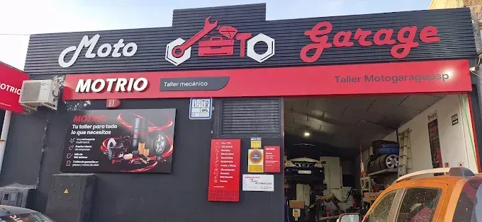 Fachada de Moto Garage con letreros rojos y negros. Una llave inglesa y otras herramientas automotrices decoran el logotipo.