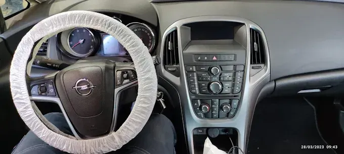 Vista interior del salpicadero de un coche y del volante recubierto de plástico.