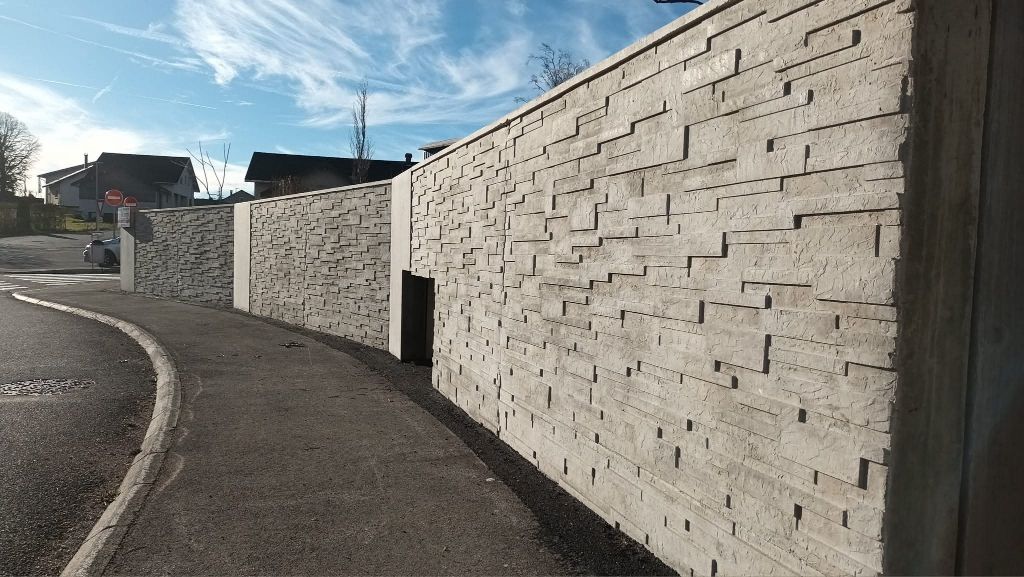 Un mur en béton matricé gris clair
