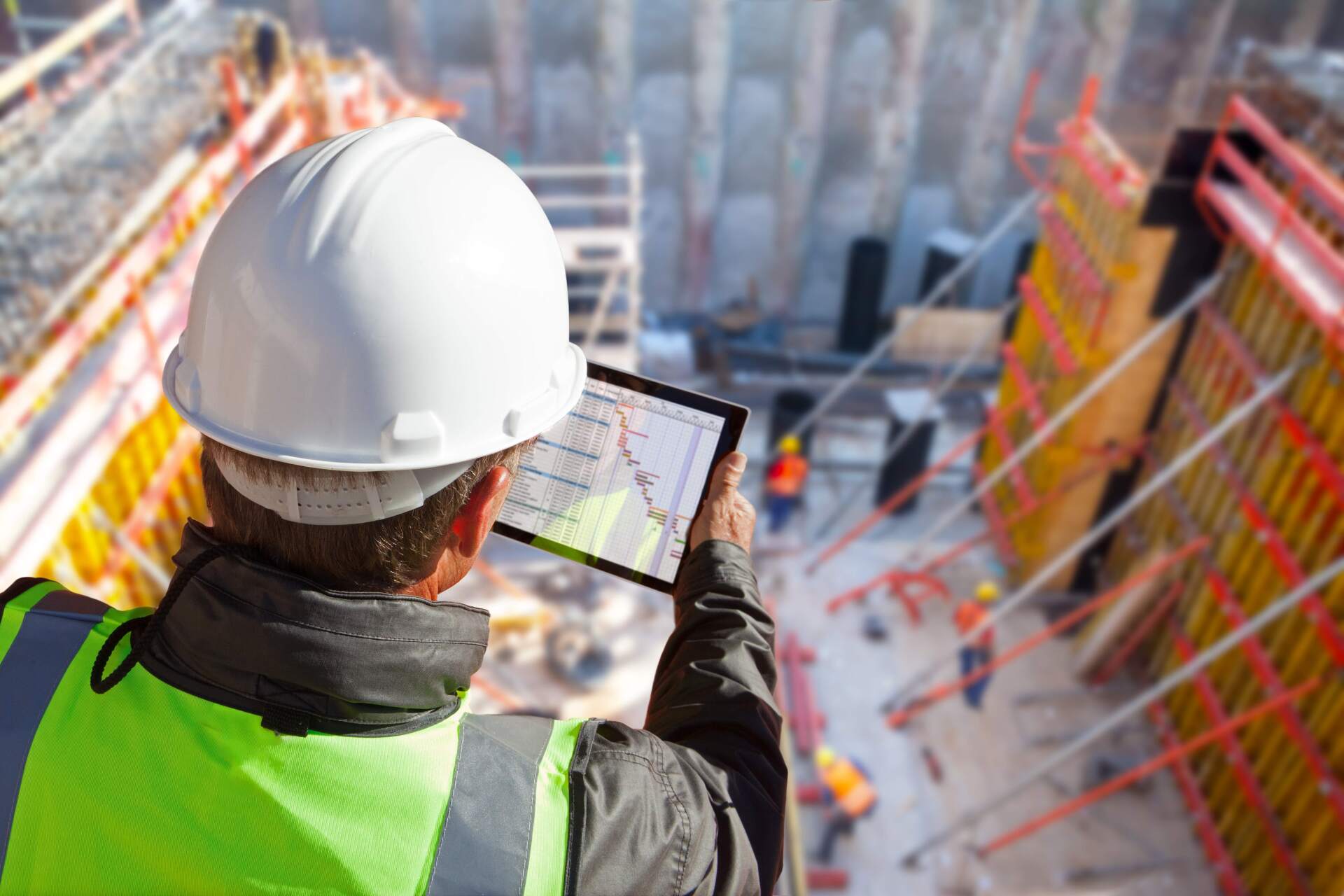 Ingénieur civil sur un chantier de construction avec une tablette informatique