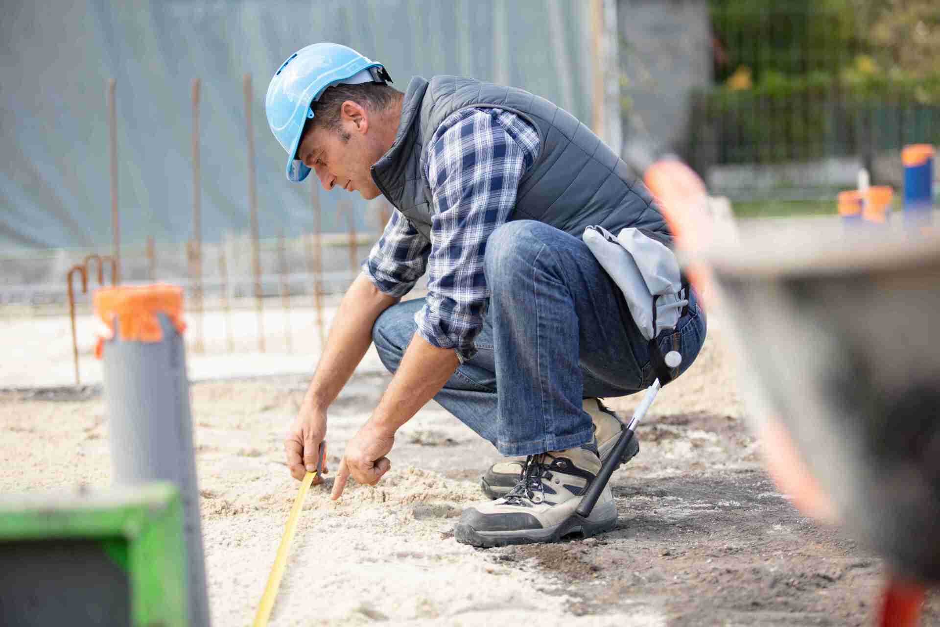 Technicien BTP mesurant le sol d'un chantier