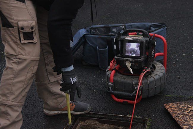 Un homme qui inspecte des canalisations avec une machine