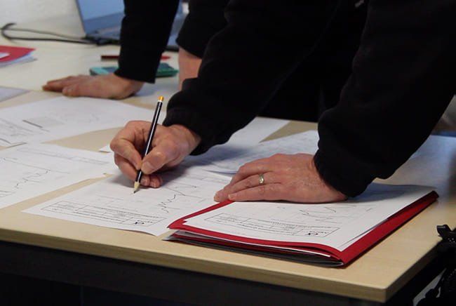 Une personne qui prend des notes sur un plan