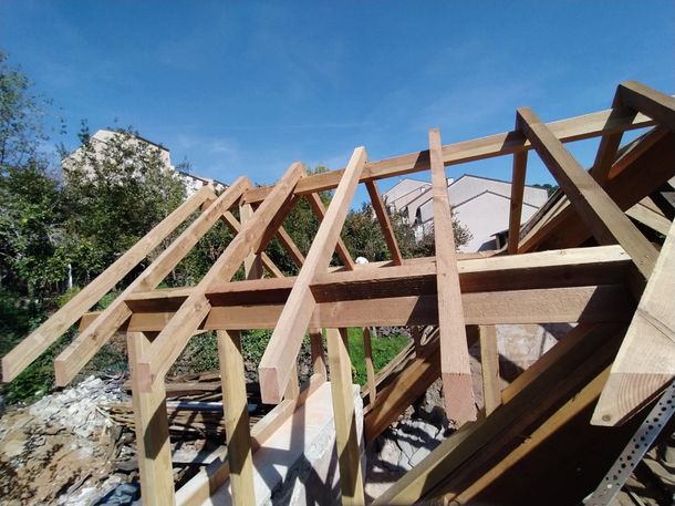 Charpente de toit en bois en construction sur fond de ciel bleu