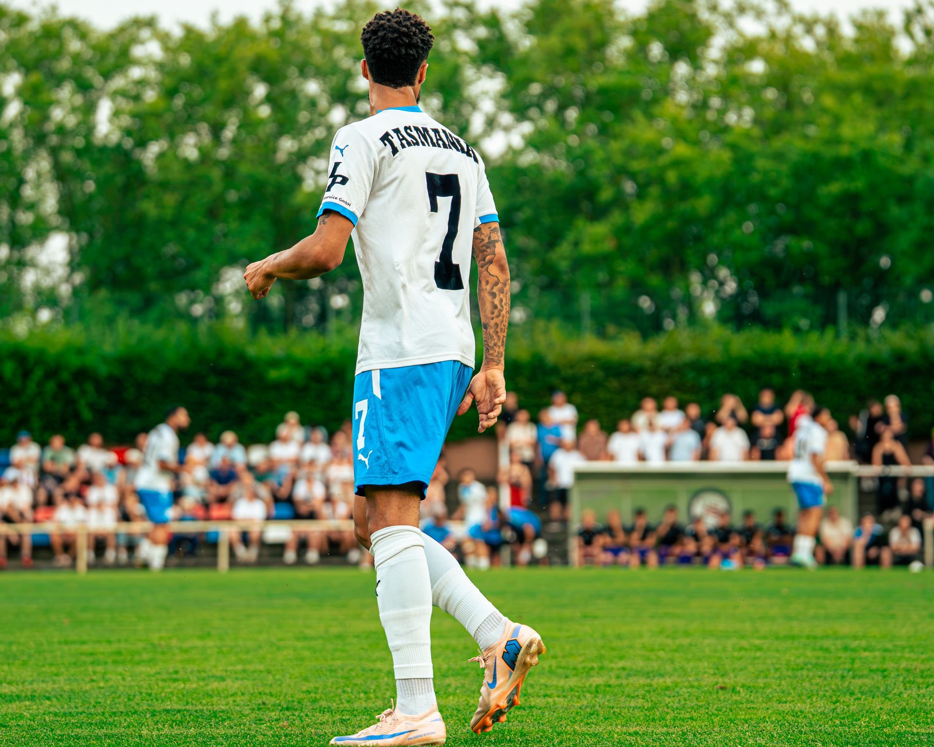 Ein Fußballspieler in weißem Trikot und blauen Shorts