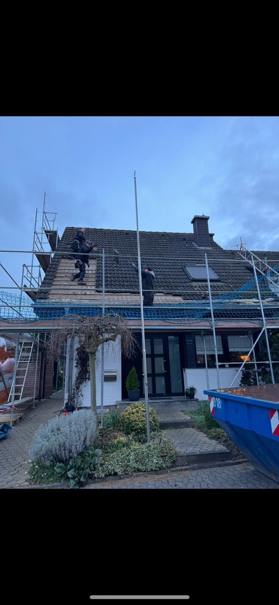 Eine Nahaufnahme eines Daches mit vielen Schindeln und Bäumen im Hintergrund.