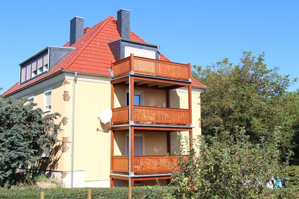 Neubau mit Holzbalkonanlage im Erdgeschoß, ersten und zweiten Stock