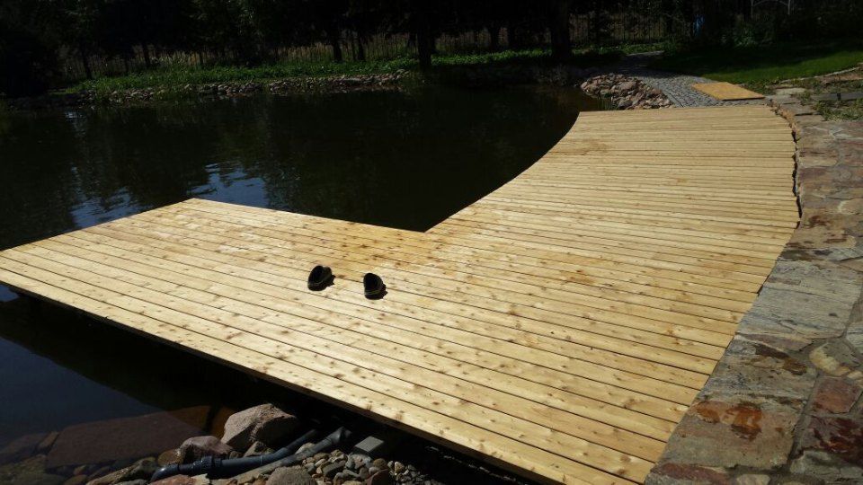 Geschwungene Holzterrasse mit Bootssteg