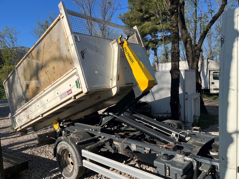 Livraison d'une benne à déchets par un camion-benne
