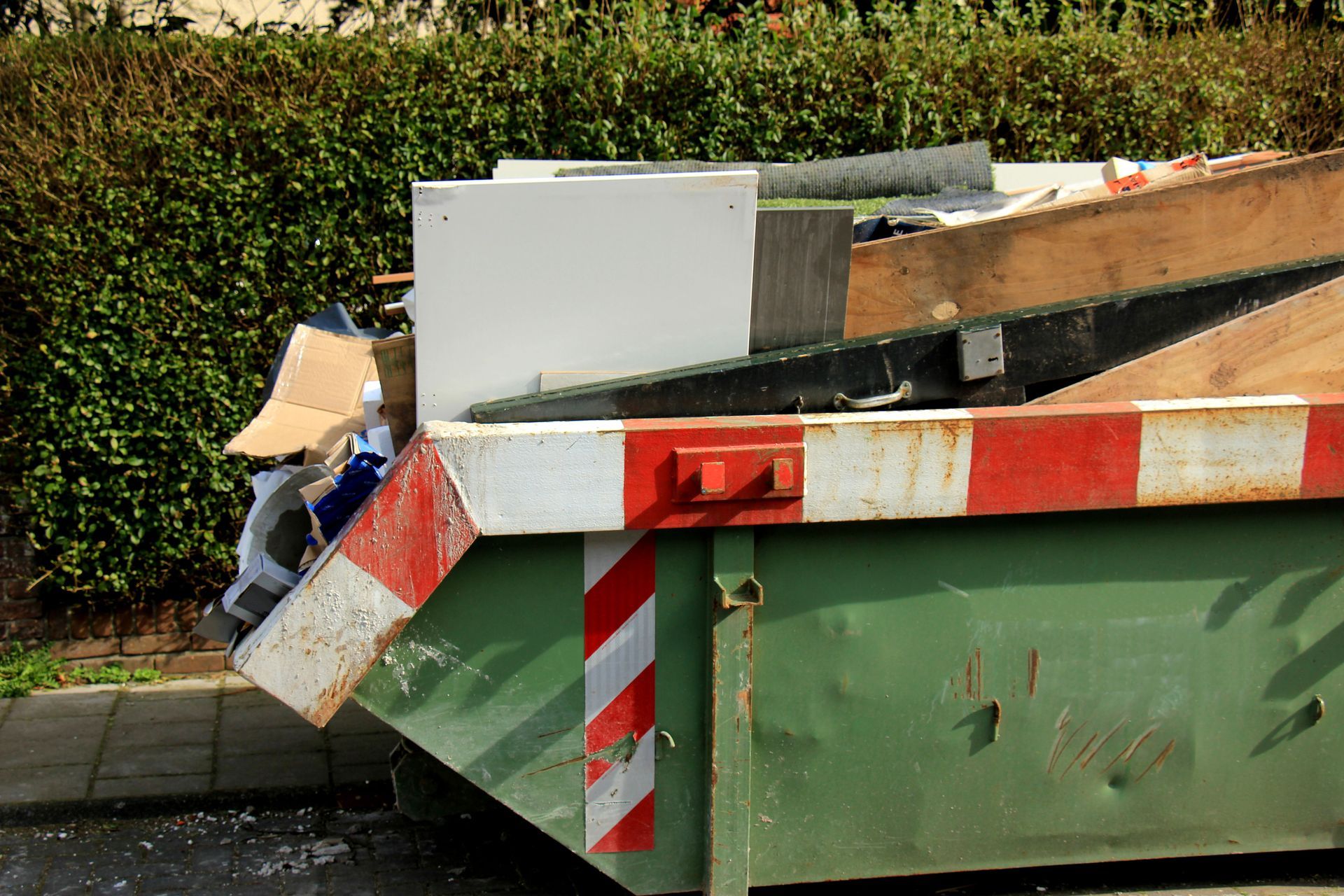 Benne à tout-venant contenant des planches d'aggloméré et du carton