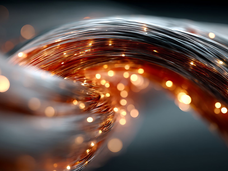 Un câble à fibre optique métallique couleur cuivre se courbe gracieusement sur un fond sombre.