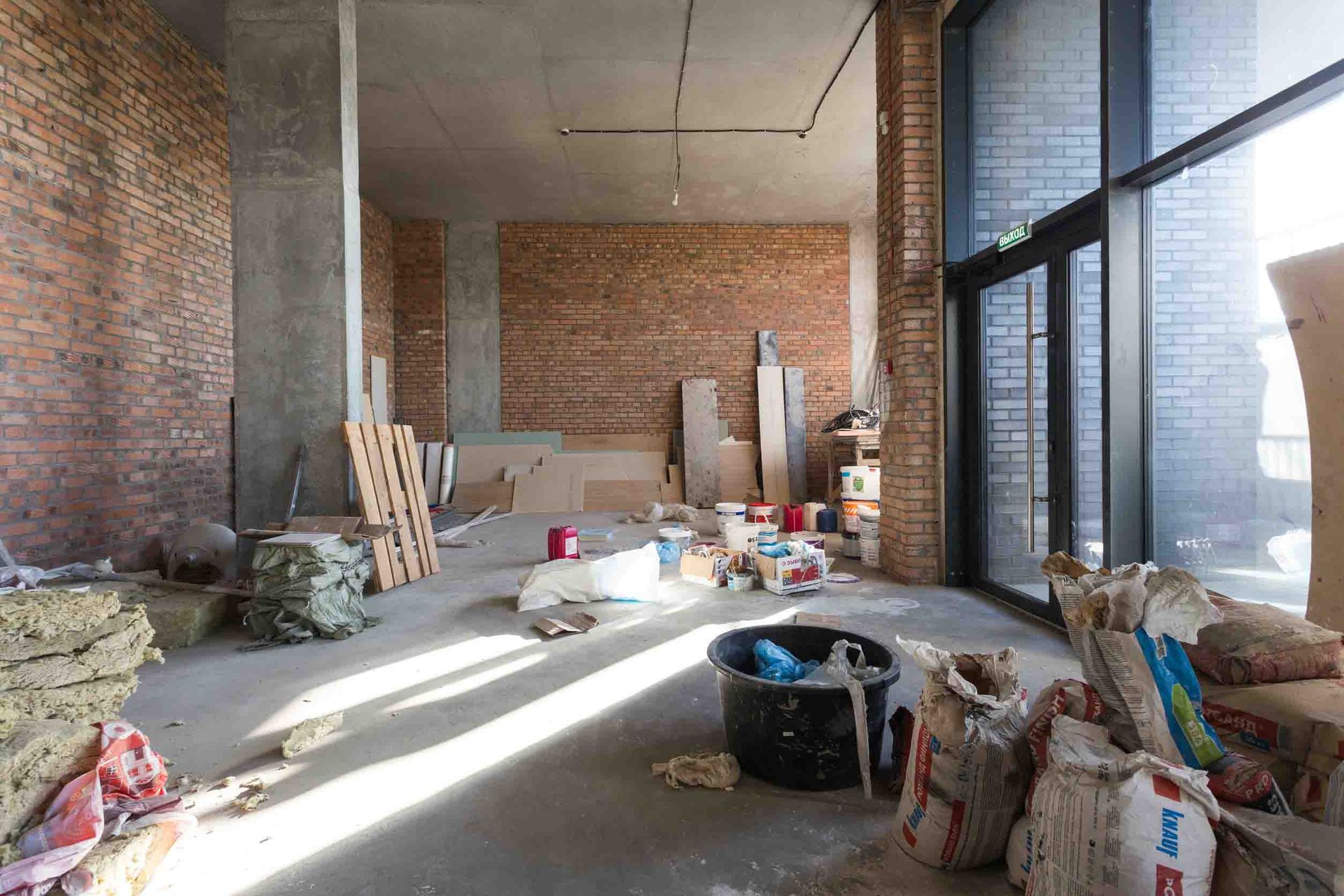 Una gran habitación vacía con paredes de ladrillo y ventanas grandes.