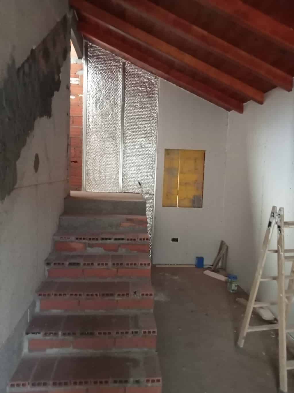 Una habitación con escaleras y una escalera en ella.