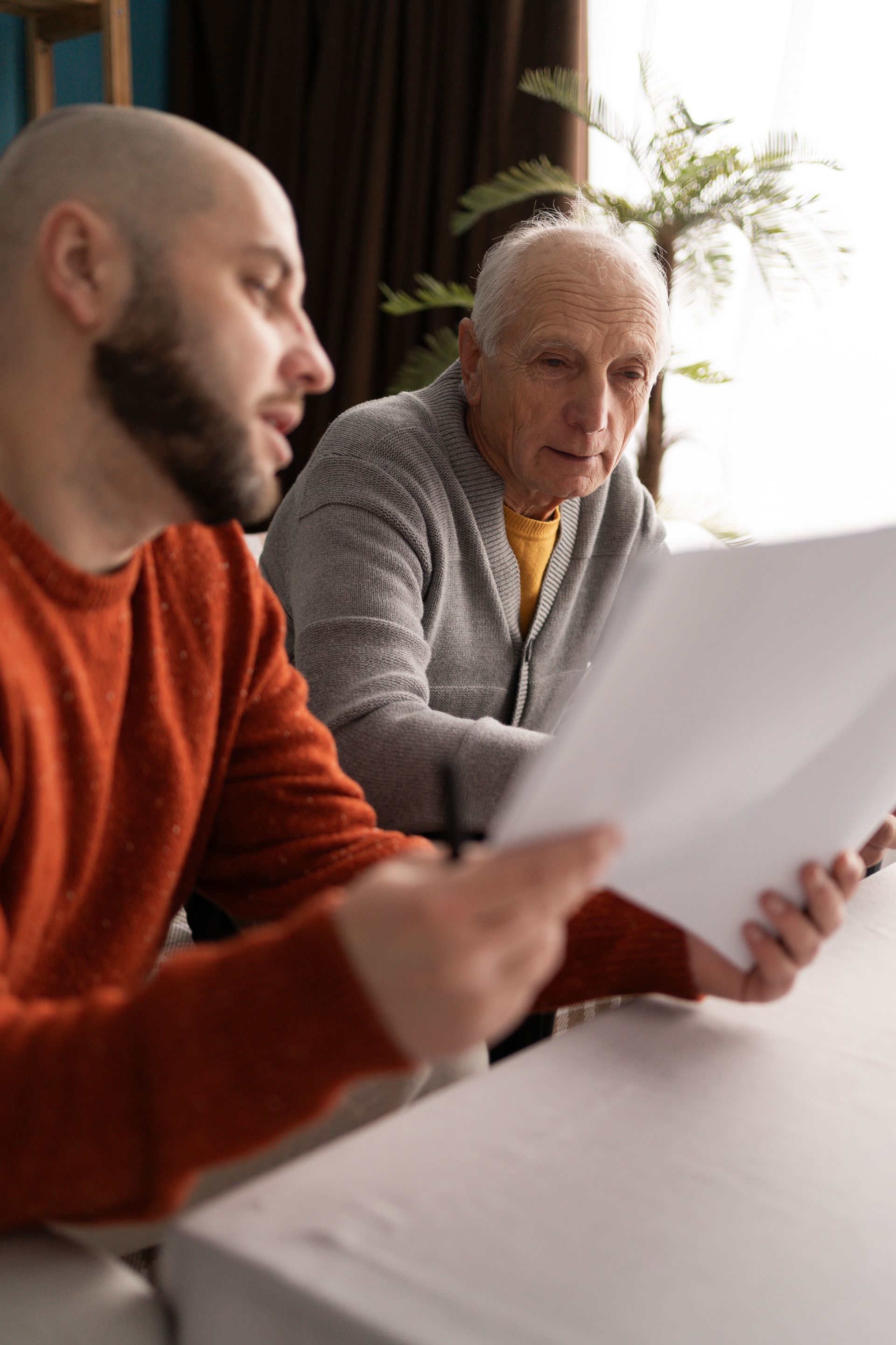 Un homme qui montre les papiers administratifs à une personne âgée.