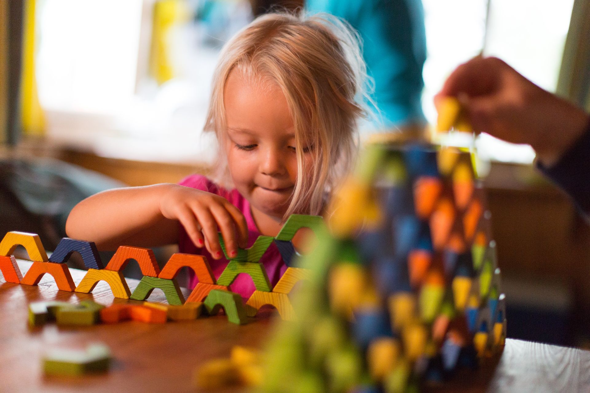 Une petite fille qui joue avec les éléments en bois.