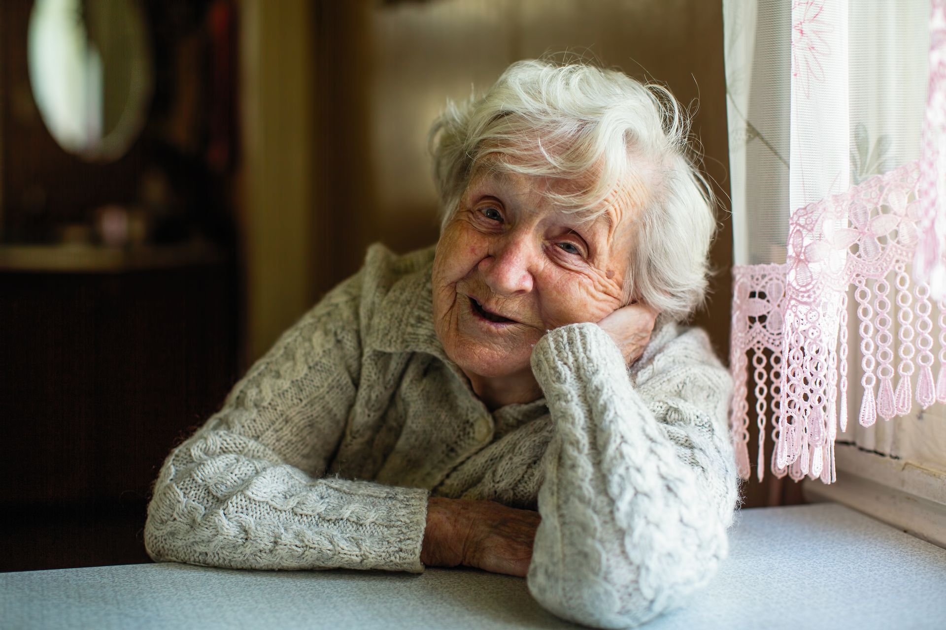 Une personne âgée assise à table.